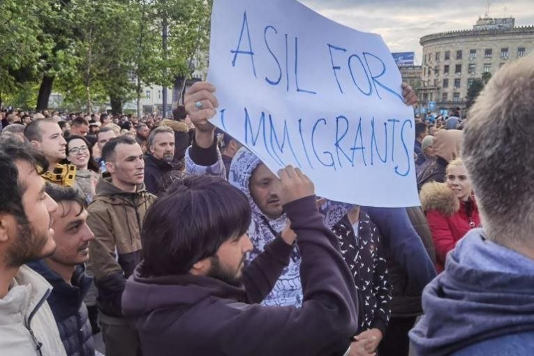 I ONI SU NA PROTESTU: Migranti sa transparentom uočeni na opozicionom skupu (FOTO)